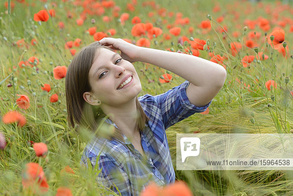 Young woman in a poppy field