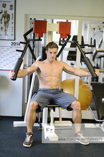 Junger Mann trainiert im Fitnesscenter