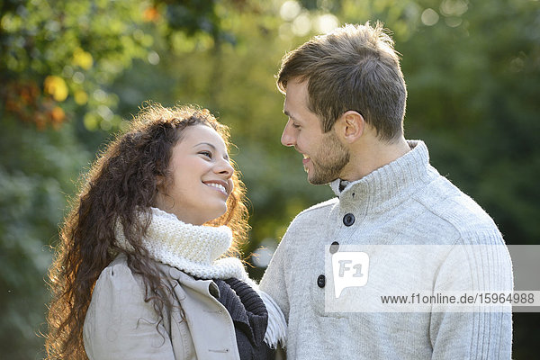 Lächelndes Paar umarmt sich im Herbst