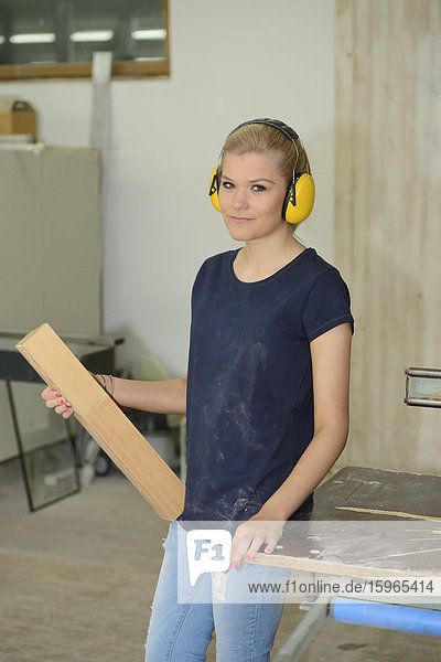 Junge Frau bei der Arbeit in einer Schreinerei
