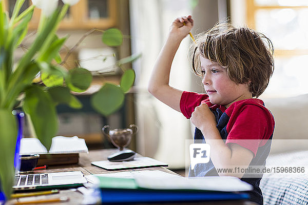 6-jähriger Junge benutzt Laptop für Fernschulung zu Hause