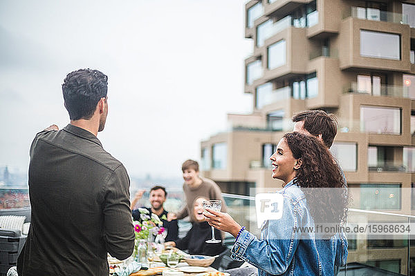 Young male and female friends enjoying during social gathering on rooftop