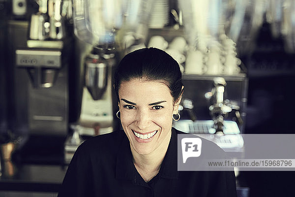 Porträt einer lächelnden Besitzerin im Cafe stehend
