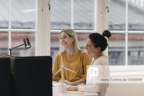 Smiling businesswomen working at desk in office