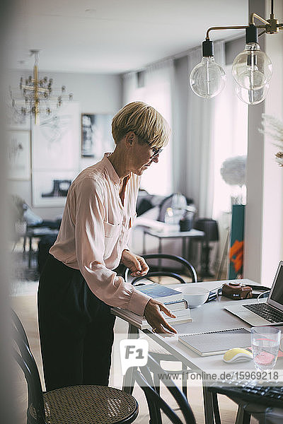 Woman standing at table working at home