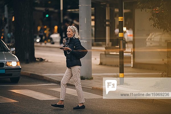 Ältere Frau schaut weg  während sie auf einem Zebrastreifen in der Stadt geht