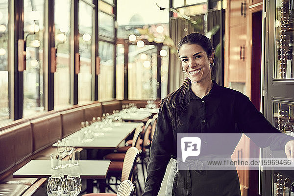 Portrait of smiling female owner standing in cafe