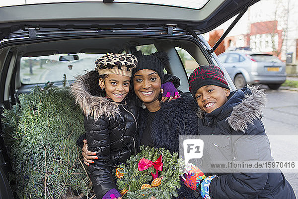 Porträt glückliche Mutter und Kinder mit Weihnachtsbaum und Kranz