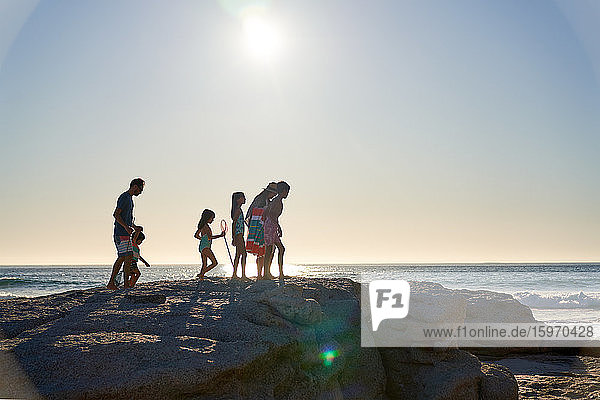 Familienspaziergang auf Felsen am sonnigen Strand des Ozeans  Kapstadt  Südafrika
