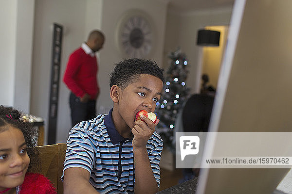 Junge isst Apfel zu Hause