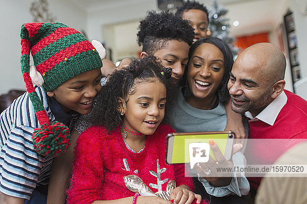 Happy family taking Christmas selfie with smart phone
