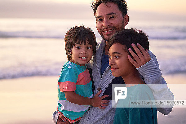 Porträt glücklicher Vater und Söhne am Strand des Ozeans