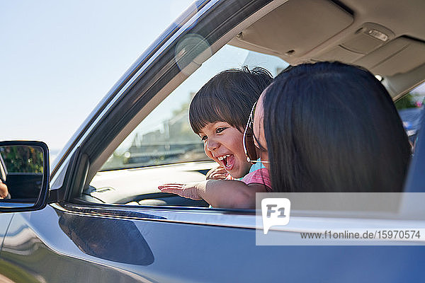 Happy mother and son in sunny car