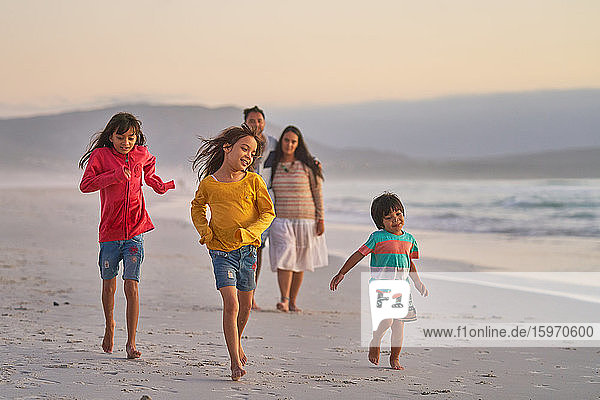 Happy family running on ocean beach