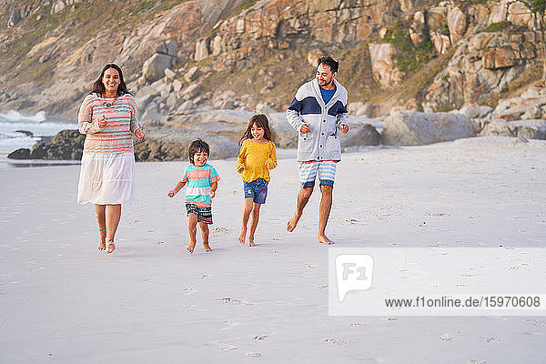 Happy family running on beach