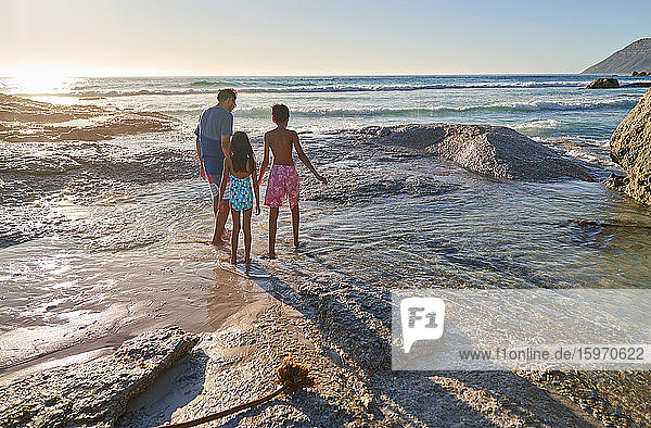 Familienspaziergang auf Felsen am sonnigen Strand des Ozeans  Kapstadt  Südafrika