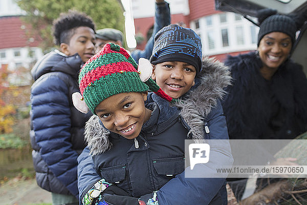 Portrait happy brothers in winter coats and hats hugging