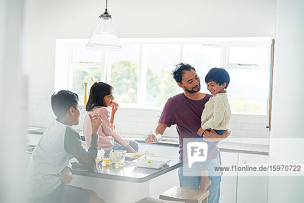 Father and kids eating in kitchen