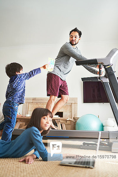 Kids in living room with father on treadmill