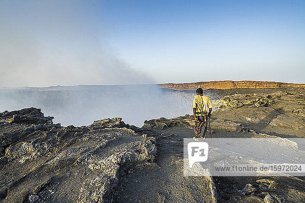 Afar man looking down to Erta Ale volcano caldera  Danakil Depression  Afar Region  Ethiopia  Africa