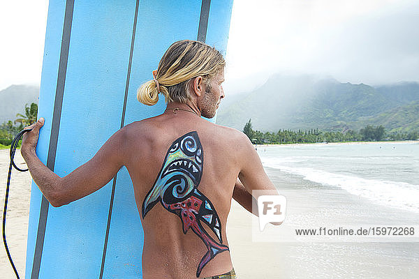 Surfer in der Hanalei-Bucht  mit einem auf den Rücken gemalten Hai  Kauai  Hawaii  Vereinigte Staaten von Amerika  Nordamerika