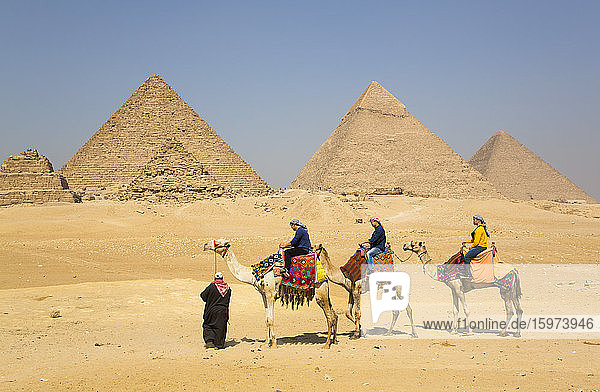 Tourists riding camels  Great Pyramids of Giza  UNESCO World Heritage Site  Giza  Egypt  North Africa  Africa