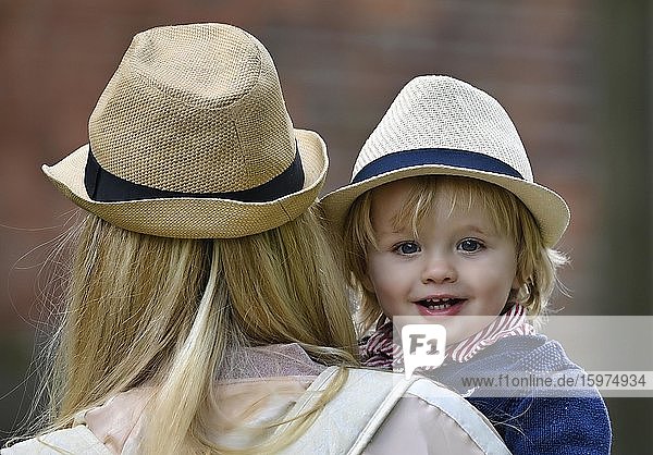 Mutter hält Sohn  19 Monate  auf Arm  beide tragen ähnlichen Hut  Stuttgart Baden-Württemberg  Deutschland  Europa