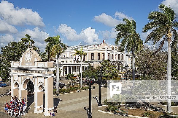 Neoklassizistische Gebäude mit Säulengang umrahmen den Parque José Martí  unten links posiert ein tanzender Chor für ein Foto.  Cienfuegos  Kuba  Mittelamerika