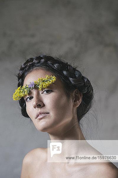 Schöne junge Frau mit Blume auf der Stirn