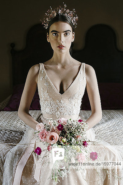 Junge Frau im Hochzeitskleid mit Blumenstrauß