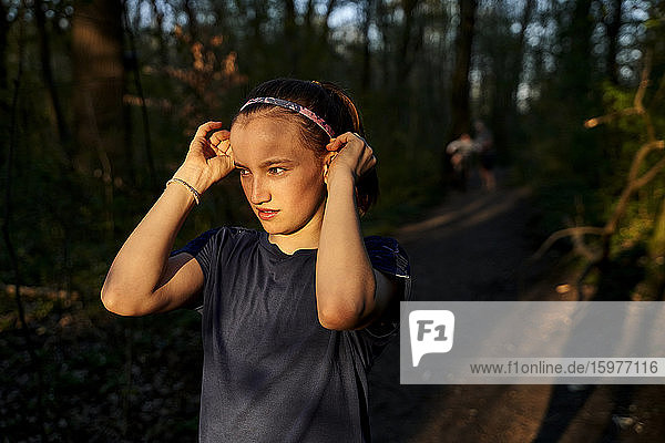 Mädchen schaut weg und trägt ein Stirnband im Wald