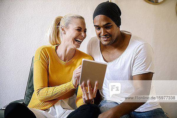 Porträt eines Paares  das zu Hause ein digitales Tablet benutzt