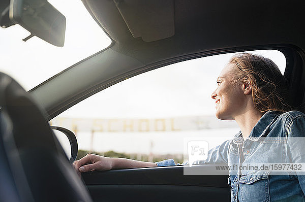 Glückliche Frau sitzt im Auto und schaut aus dem Fenster  Sardinien  Italien