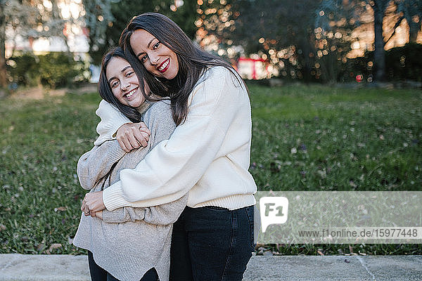 Mother and daughter hugging in a park