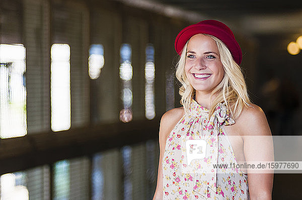 Porträt einer glücklichen jungen Frau mit rotem Hut