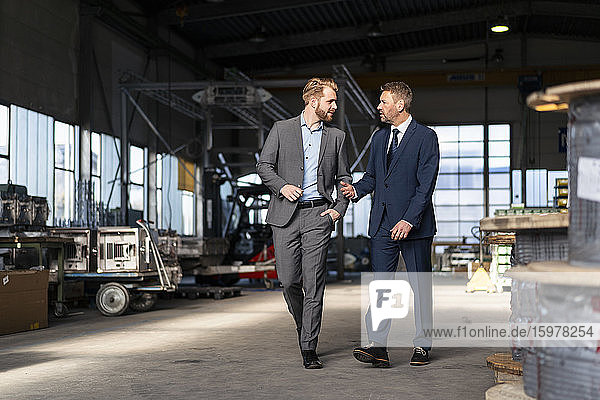 Zwei Geschäftsleute  die sich in einer Fabrik unterhalten