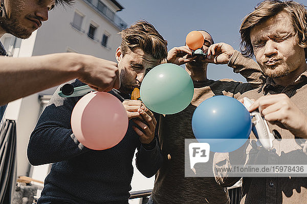Group of friends playing with balloons ona balcony
