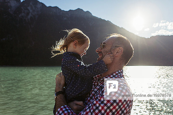 Vater trägt Tochter gegen Berg und See am Achensee  Bundesland Tirol  Österreich