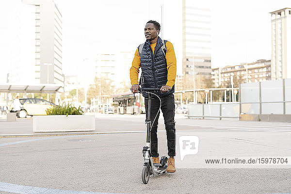 Young man riding e-scooter in the city