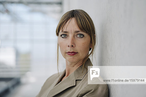 Porträt einer selbstbewussten Geschäftsfrau vor einer Betonwand