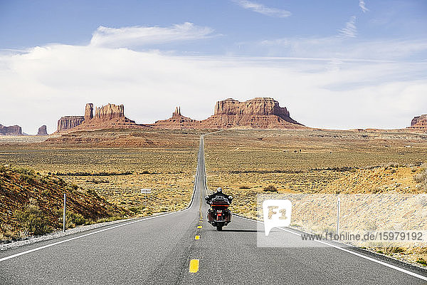 Rückansicht eines Mannes beim Motorradfahren auf der Wüstenstraße  Monument Valley Tribal Park  Utah  USA
