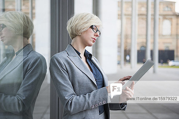Porträt einer blonden Geschäftsfrau mit Tablet in der Stadt