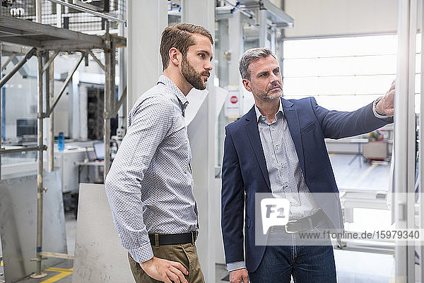 Zwei Geschäftsleute bei einem Treffen in einer Fabrik
