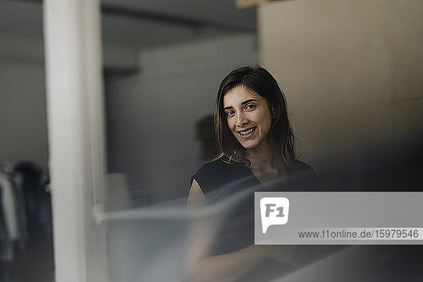 Porträt einer lächelnden jungen Geschäftsfrau in einem Loft