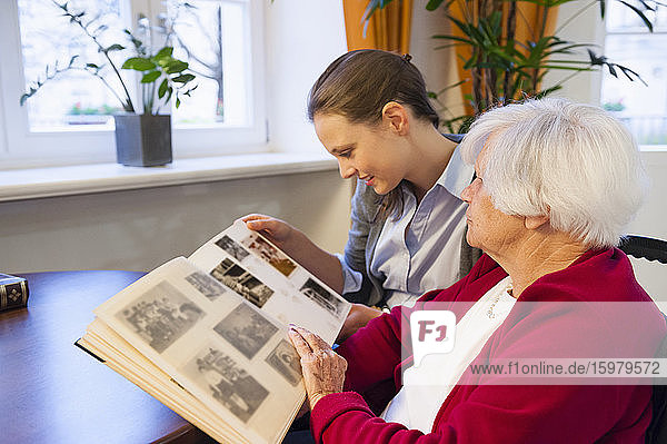 Großmutter und Enkelin schauen sich zu Hause ein Fotoalbum an