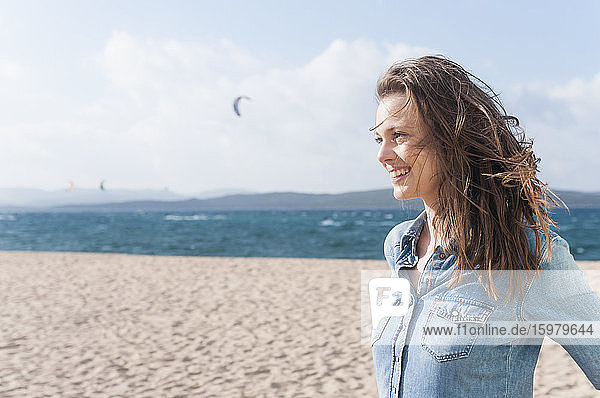 Portrait of happy woman with blowing hair on the beach  Sardinia  Italy