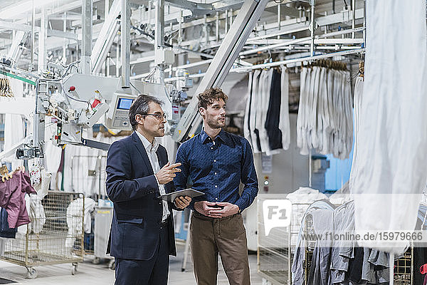 Two businessmen having a meeting in a laundry shop