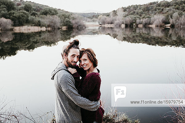 Portrait of happy affectionate couple at lakeside