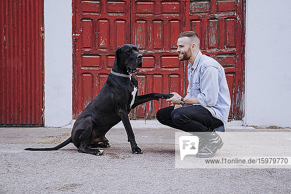 Young man teaching his dog outdoors