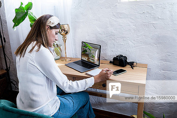 Female photographer processing pictures at home